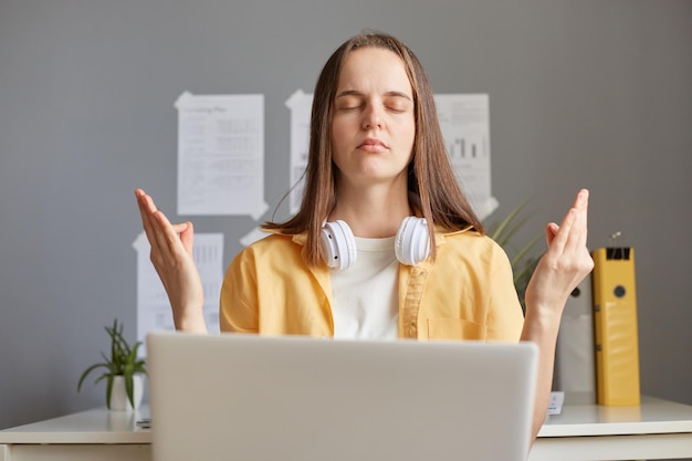 Calm relaxed woman freelance working on her laptop enjoying peace and quiet of her home office meditating and relaxing while having break online remote job