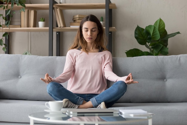 Photo calm woman relax on couch meditating practicing yoga