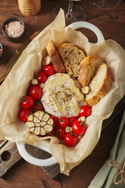 Camembert cheese baked with cherry tomatoes and baguette