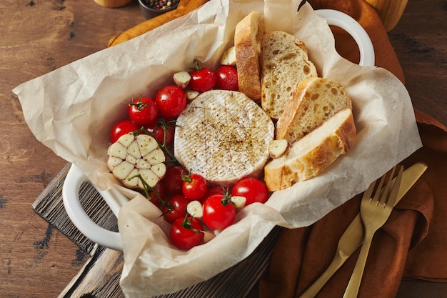 Camembert cheese baked with cherry tomatoes and baguette