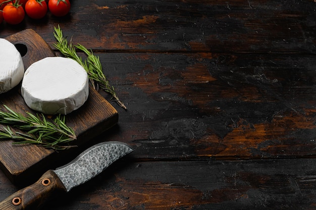 Camembert cheese on old dark wooden table background with copy space for text