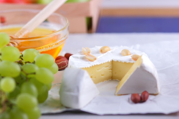 Camembert French cream cheese made from cow's milk served with honey and fruit Food for a healthy and tasty snack on a white background Closeup