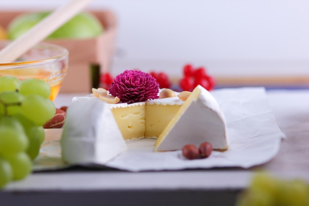 Camembert French cream cheese made from cow's milk served with honey and fruit Food for a healthy and tasty snack on a white background Closeup