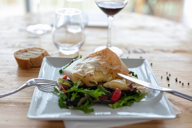 Camembert melted in a sheet of brick pastry on a salad