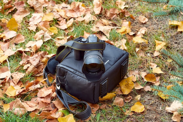 Camera on a bag among yellow leaves