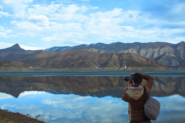 Camera in the photographer hand in lake backgroundxA