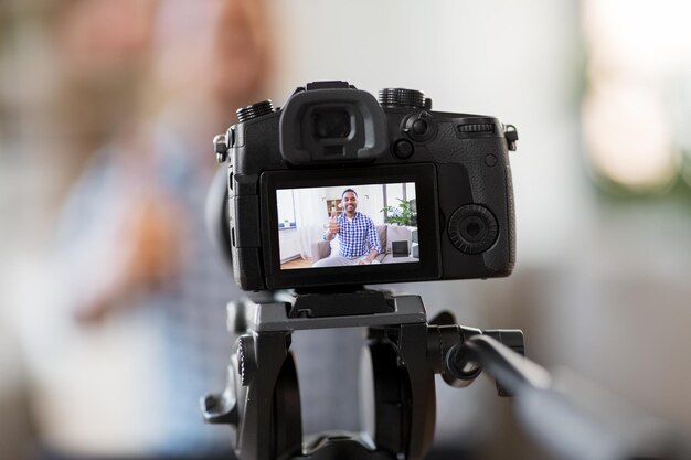 Photo camera recording video blogger showing thumbs up