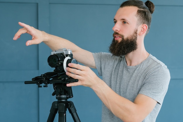 Cameraman instructions. video shooting process. man holding camera and pointing with finger directing   on the set.