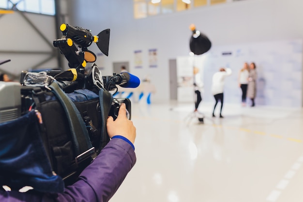 Cameraman using black professional digital video camera