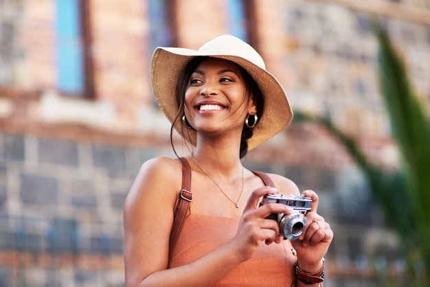 Cameras are the best traveling buddies Shot of an attractive young woman taking pictures with a camera while exploring in a foreign city