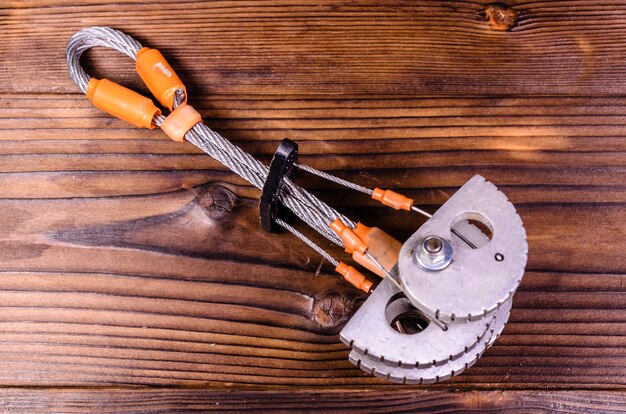 Camming device friend for rock climbing on rustic wooden table. Top view