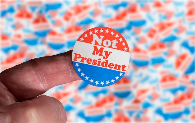 Campaign button or badge on caucasian senior finger stating Not my President in protest against ballot rigging