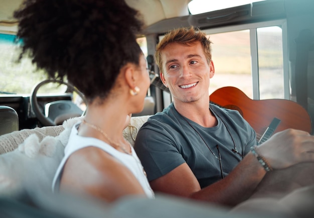 Camper van and couple relax while travel happy talking and bonding in their vehicle together Love freedom and content woman and man enjoying their journey and vacation exploring and having fun