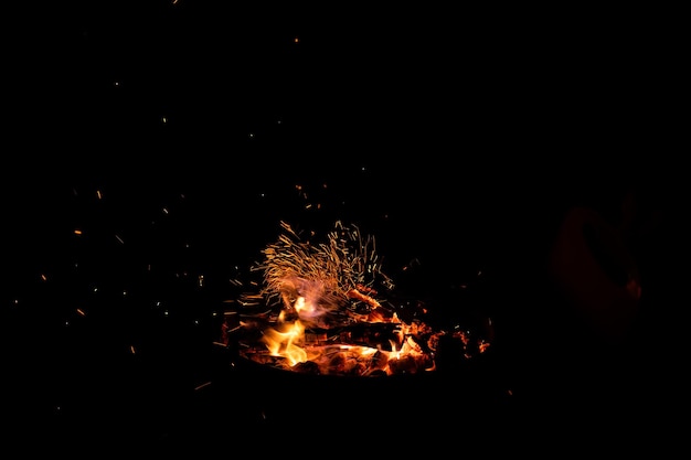 Photo campfire flame sparks isolated on black background fire flames heat energy heap in the night fire