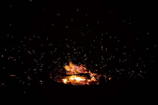 Campfire flame sparks isolated on black background fire flames heat energy heap in the night fire