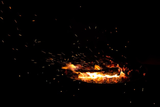 Campfire flame sparks isolated on black background fire flames heat energy heap in the night fire