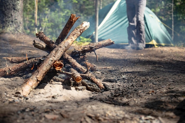 Campfire with fresh wood barely inflames