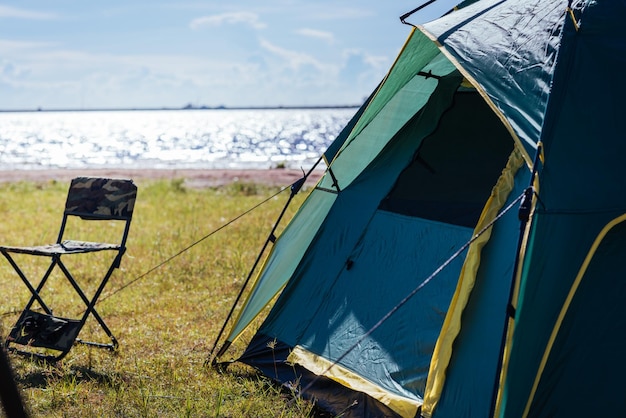 Camping green tent near lake, no people