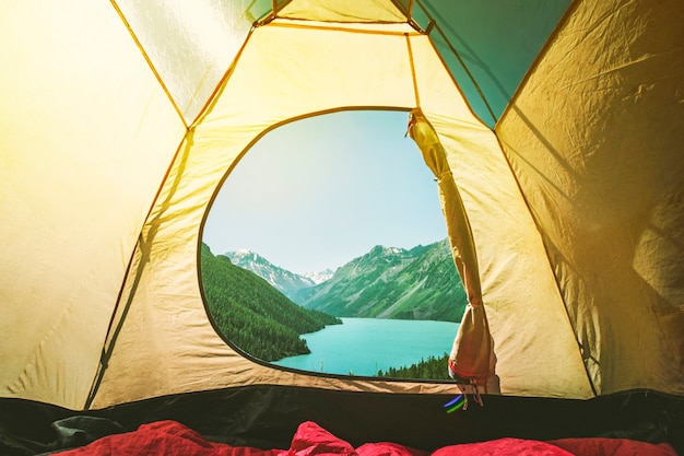 Camping tent with a beautiful view of a lake in Mountain lake Kucherlinskoe from above, Altay, Russia. Camping in the woods.