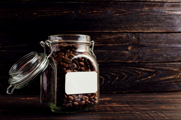 A can of coffee beans stands on a wooden table.