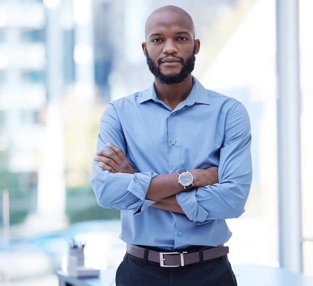 Can we do some business. Shot of a young businessman standing with his arms crossed in an office at work.