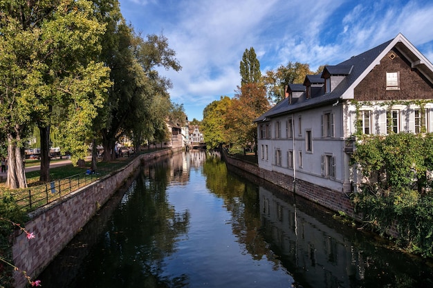 Canal amidst trees and buildings against sky