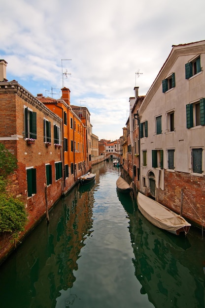 Canal by houses against sky