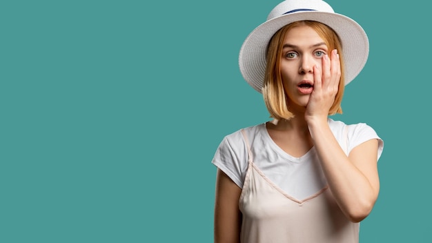 Canceled vacation Travel ban Shocked woman white outfit and hat looking at camera isolated on green copy space Summer holiday Advertising background