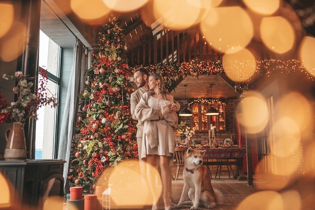 Candid authentic happy married couple spends time together with japanese dog at Xmas lodge