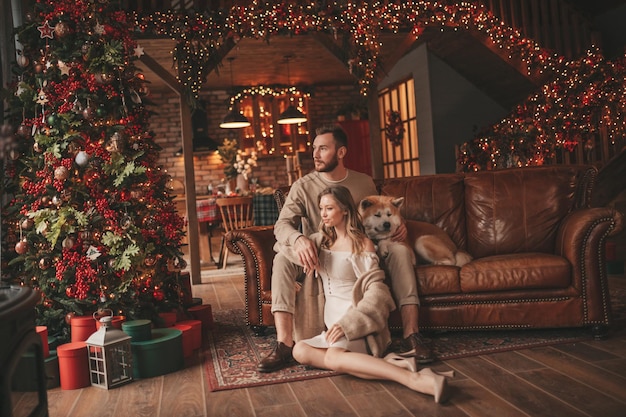 Candid authentic happy married couple spends time together with japanese dog at Xmas lodge