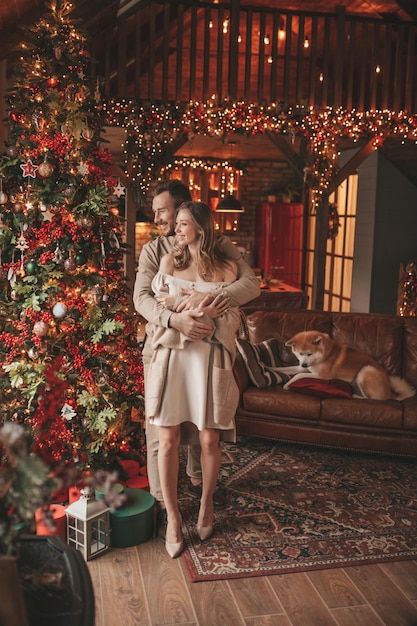 Candid authentic happy married couple spends time together with japanese dog at Xmas lodge