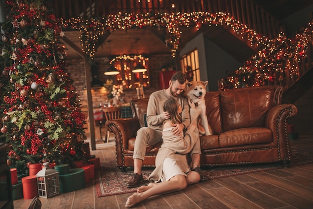 Candid authentic happy married couple spends time together with japanese dog at Xmas lodge