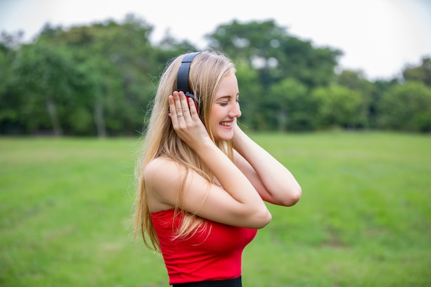 candid shot of women listening music on headphone in park