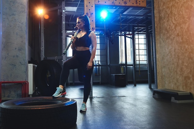 Candid strong young woman is posing with a hammer in the gym strength training Real wokout