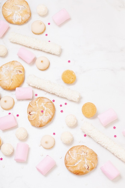 Candies and cookies on white marble background