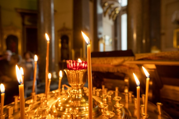 Candle church A row of lighted wax candles in the Christian Orthodox Church on a dark blurred background