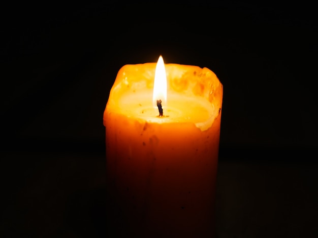 Photo candle on a dark wall. burning candle during the festival of light. candle in the dark wall.