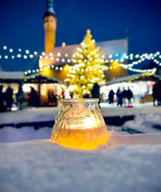 candle light in snow ,Christmas tree ,winter evening ,people walk in Tallinn old town hall square