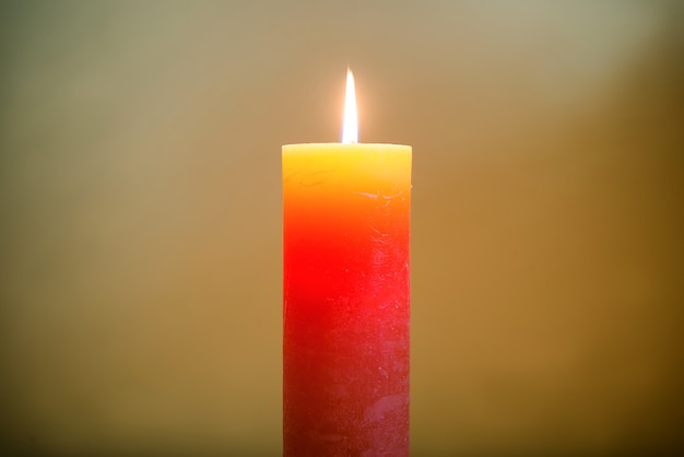 Candle light with flame on dark soft background