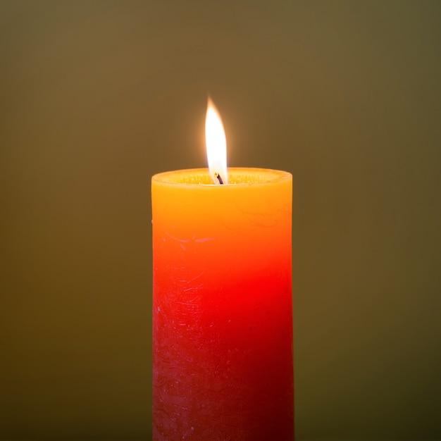 Candle light with flame on dark soft background