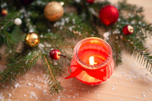 Candle near decorated Christmas tree