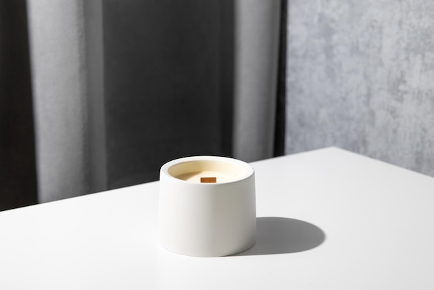 Candle soy homemade in ceramic burning in grey modern interior room atmosphere and minimalistic comp