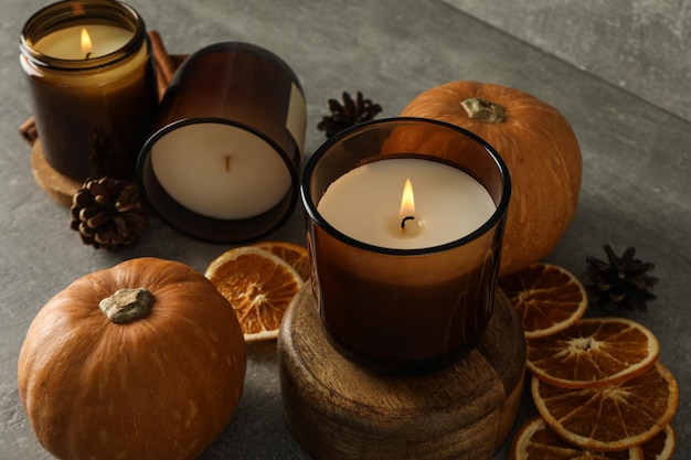 Candles pumpkins and orange on gray background