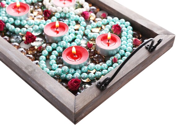 Candles on vintage tray with decorative beads, stones, isolated on white