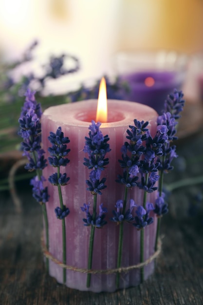 Candles with lavender flowers on table close up