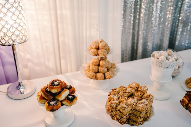 Candy bar Table with muffins cakes sweets candy buffet Dessert table for a party goodies for the wedding banquet area Decorated delicious