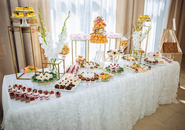 Candy bar at the wedding reception Cupcakes and sweets Beautiful decorations White flowers Delicious desserts