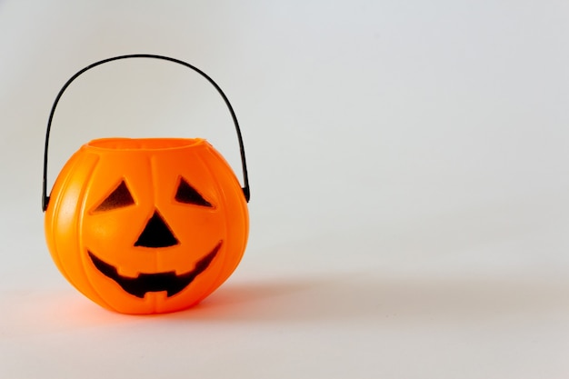 Candy basket in the shape of halloween lantern pumpkin on white background Copy space