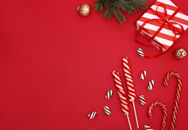 Candy cane for party design on red background. Christmas composition. Flat lay, top view.