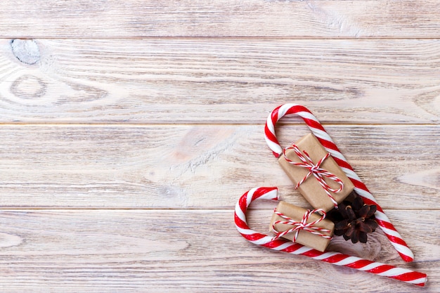 Candy canes and christmas gift on brown wooden background